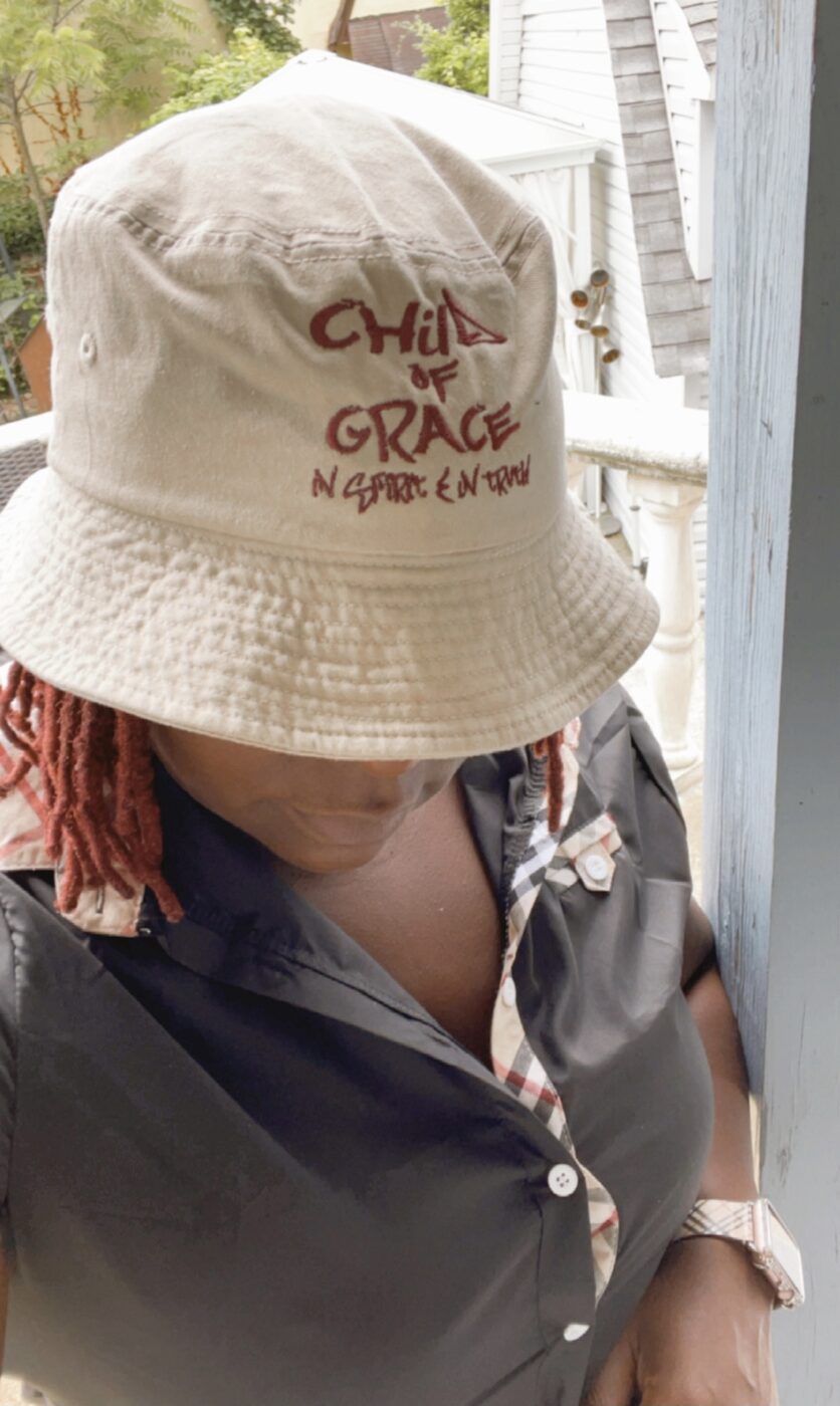 Model wearing the distressed white CHILD OF GRACE embroidered bucket hat